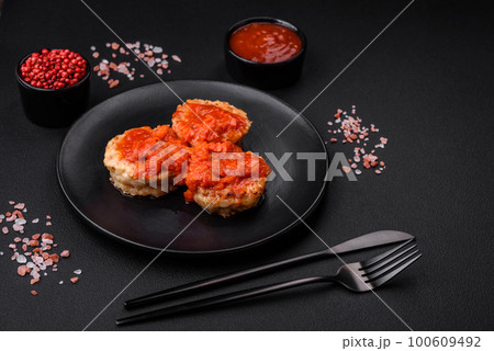 Delicious fresh cutlets or meatballs with spices, herbs and tomato sauce Delicious fresh cutlets or meatballs with spices, herbs and tomato sauce 100609492