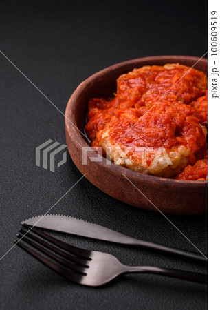 Delicious fresh cutlets or meatballs with spices, herbs and tomato sauce Delicious fresh cutlets or meatballs with spices, herbs and tomato sauce 100609519
