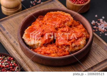 Delicious fresh cutlets or meatballs with spices, herbs and tomato sauce Delicious fresh cutlets or meatballs with spices, herbs and tomato sauce 100609523