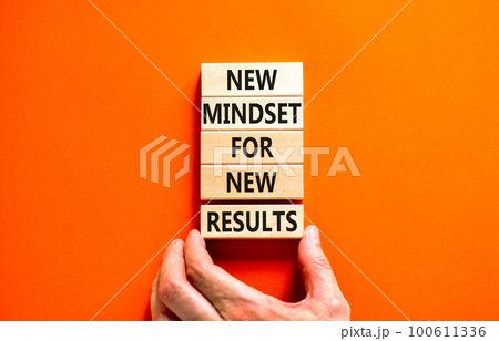 New mindset and results symbol. Concept words New mindset for new results on wooden blocks. Beautiful orange background. Businessman hand. Business new mindset for results concept. Copy space 100611336
