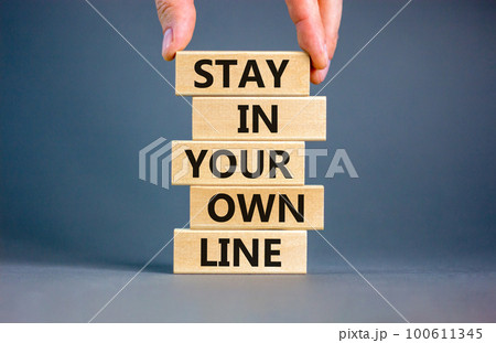 Stay in your own line symbol. Concept words Stay in your own line on wooden blocks. Businessman hand. Beautiful grey table grey background. Business and stay in your own line concept. Copy space. 100611345