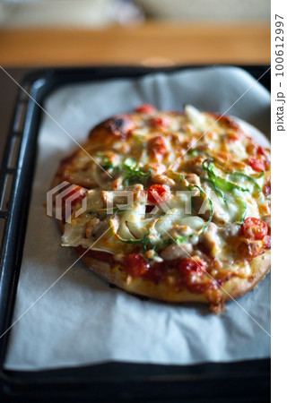 手作りのピザが焼けてオーブンから取り出したところ 手作りのピザが焼けてオーブンから取り出したところ 100612997