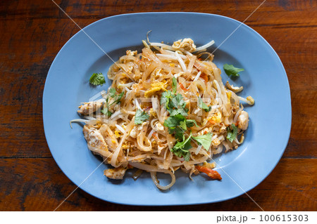 Overhead view of authentic and simple no frills Pad Thai, popular Thailand street food made up of fried rice noodle with added shrimps, pork or chicken. Overhead view of authentic and simple no frills Pad Thai, popular Thailand street food made up of fried rice noodle with added shrimps, pork or chicken. 100615303