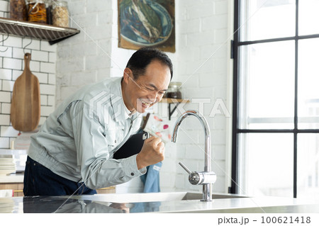 水道を点検する作業着の男性 100621418