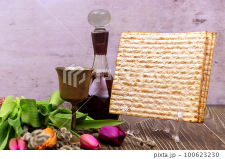 During Jewish holiday of Pesach cup of kosher kiddush wine is with unleavened bread called matzah soft focus 100623230