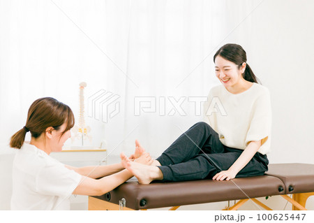 リフレクソロジー・足ツボマッサージにきた患者と整体師・マッサージ師・セラピスト・医師の女性 リフレクソロジー・足ツボマッサージにきた患者と整体師・マッサージ師・セラピスト・医師の女性 100625447
