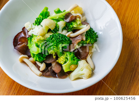 Healthy food menu, stir-fried mushrooms, cauliflower, and broccoli, Thai healthy mix vegetable food on a white plate. Close-up image, view from above. Healthy food menu, stir-fried mushrooms, cauliflower, and broccoli, Thai healthy mix vegetable food on a white plate. Close-up image, view from above. 100625456