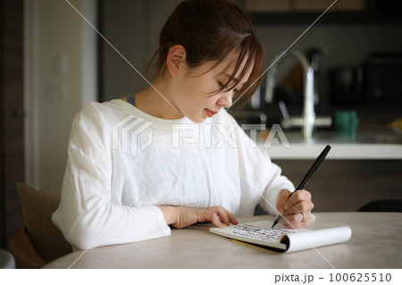 筆ペンで字を書く女性 100625510