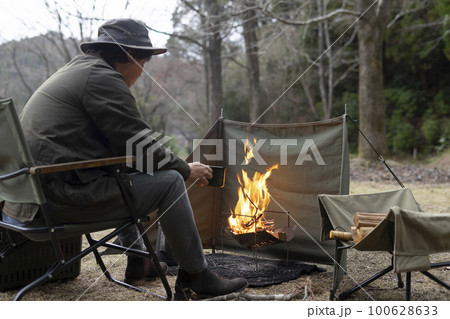 ソロキャンプで焚き火をする男性 ソロキャンプで焚き火をする男性 100628633