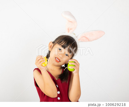 Happy Easter Day. Smile Asian little girl wearing easter bunny ears holding colorfull eggs on hands isolated on white background with copy space, Happy child in holiday Happy Easter Day. Smile Asian little girl wearing easter bunny ears holding colorfull eggs on hands isolated on white background with copy space, Happy child in holiday 100629218