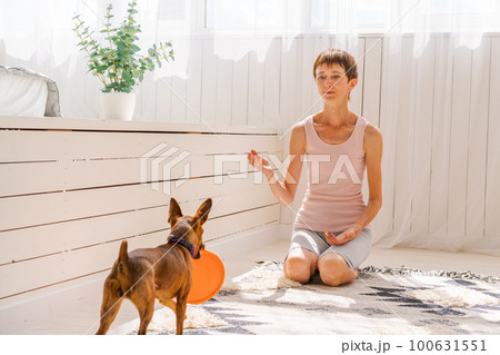 Woman practicing exercising with dog to enjoying and relaxing with yoga. Spend 100631551