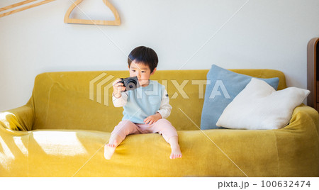 親のデジカメで遊ぶ3歳の男の子 100632474