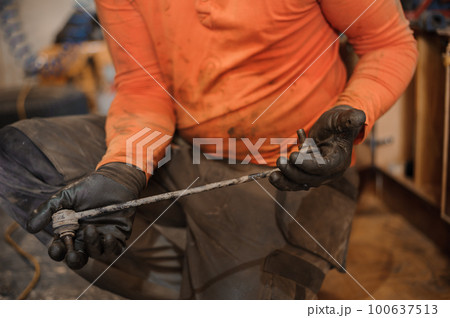 Mechanic man repairs the undercarriage of the car. A man repairs a car in a garage. Car wheel repair Mechanic man repairs the undercarriage of the car. A man repairs a car in a garage. Car wheel repair 100637513
