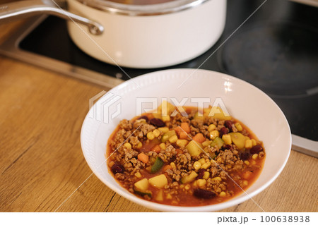 Finished traditional Mexican dish in a plate near the saucepan. Spicy food 100638938