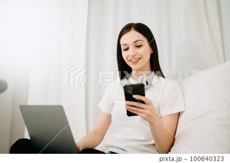 Beautiful woman has woken up on a white bed and holding coffee in the morning at home in morning 100640323