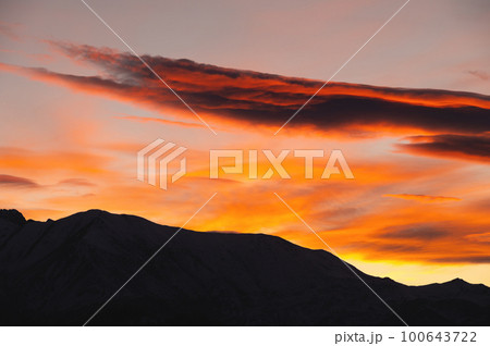 silhouette of the mountain and the sunset sky. Colorful red sunset, in the foreground the silhouette of the ridge of the rocky mountains 100643722