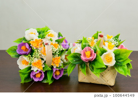 Bouquets of fragrant crocuses of daffodils from handmade soap in baskets on a white background. 100644549