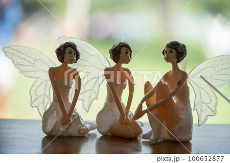 Three angel figure dolls with wings on wooden table Three angel figure dolls with wings on wooden table 100652877