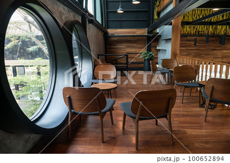 Coffee shop second floor with outdoor view from circle windows 100652894