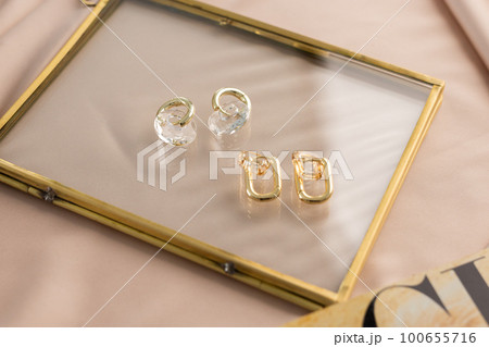 Elegant jewelry set of gold earrings. Jewelry set minimalist style. Handmade bijouterie concept. 100655716