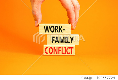Work-family conflict symbol. Concept words Work-family conflict on wooden block on a beautiful orange table orange background. Businessman hand. Business work-family conflict concept. Copy space. Work-family conflict symbol. Concept words Work-family conflict on wooden block on a beautiful orange table orange background. Businessman hand. Business work-family conflict concept. Copy space. 100657724
