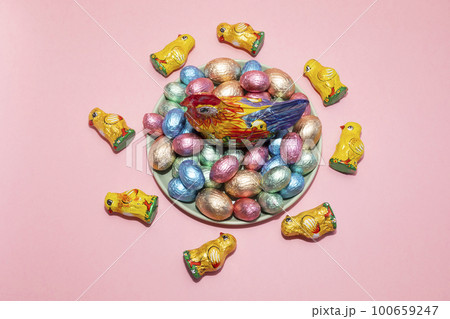 Top View Easter, Paschal kids gist. Chocolate hen, little chickens with festive colorful bright sweet eggs wrapped in foil on pink background. Confectionery, sweet-shop concept. Copy space,horizontal Top View Easter, Paschal kids gist. Chocolate hen, little chickens with festive colorful bright sweet eggs wrapped in foil on pink background. Confectionery, sweet-shop concept. Copy space,horizontal 100659247