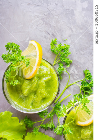 Refreshing smoothies from cucumber, green apple, fresh herbs and lemon juice in transparent glasses on the table. The concept of a healthy diet. Vegetarian menu. Top view 100660515