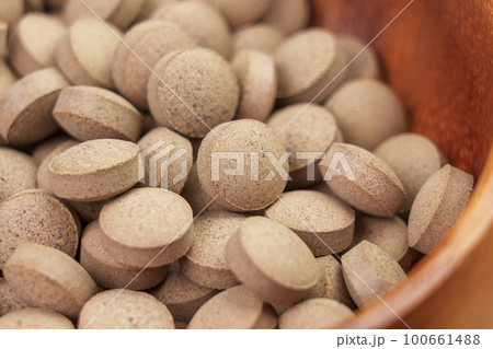 Brewer's yeast pills. Dietary supplement tablets in rustic wooden bowl 100661488