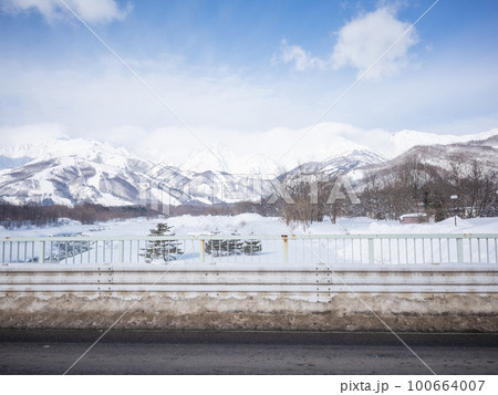 【日本】新潟、冬晴れの空と積雪した山並みと除雪された道路 【日本】新潟、冬晴れの空と積雪した山並みと除雪された道路 100664007