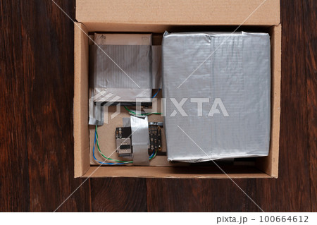 Hand made bomb with c4 and cell phone module in a cardboard box Hand made bomb with c4 and cell phone module in a cardboard box 100664612