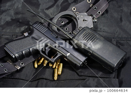 Police weapon and equipment and handcuffs on black uniform Police weapon and equipment and handcuffs on black uniform 100664634