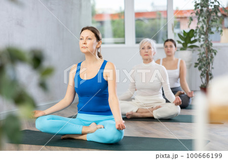 Adult woman doing yoga in fitness studio 100666199