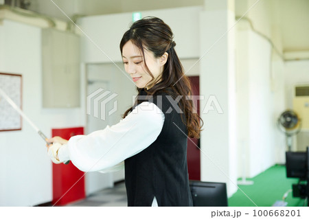 ゴルフ練習をする女性 100668201