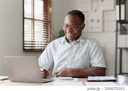 American African Businessman research and analysis with financial graph at office. Strategy, chart, finance report concept American African Businessman research and analysis with financial graph at office. Strategy, chart, finance report concept 100670161