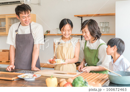 家のキッチンで子供と一緒に料理・クッキング・お手伝いする子供と夫婦・親子・家族 100672463