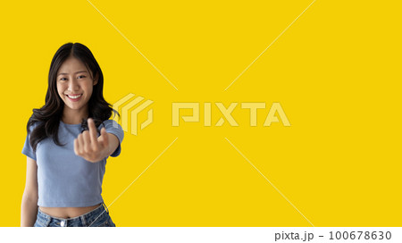 Women beckoning or inviting them to pay attention, Suggest to click or apply with me, Giving assistance and acceptance, Calling with one finger, Come and get me, Woman on yellow background. Women beckoning or inviting them to pay attention, Suggest to click or apply with me, Giving assistance and acceptance, Calling with one finger, Come and get me, Woman on yellow background. 100678630