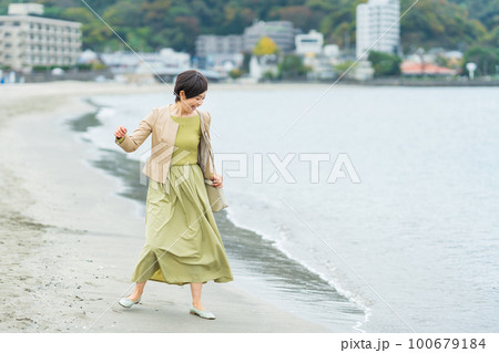 海辺を歩くミドルの女性 100679184