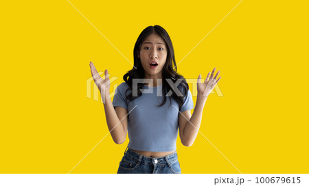 Asian woman acting shocked or surprised isolated on a white background,  Looking camera, Concept acts according to the emotions and feelings of excitement and shock, Yellow background, Copy space. 100679615