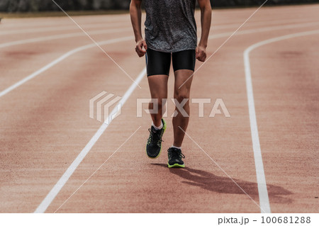 陸上競技のトラックの直線を走る男性ランナー 100681288
