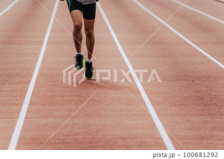 陸上競技のトラックの直線を走る男性ランナー 100681292