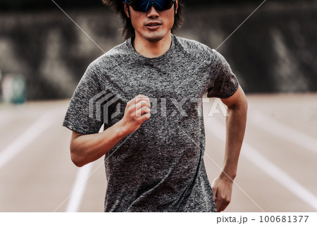 陸上競技のトラックの直線を走るサングラスをかけた男性ランナー 陸上競技のトラックの直線を走るサングラスをかけた男性ランナー 100681377
