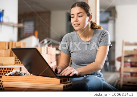 Woman with laptop on indoor construction site Woman with laptop on indoor construction site 100681413