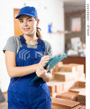 Woman architect taking notes on construction site 100681443