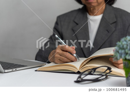 Woman hands with pen writing on notebook in the office.learning, education and work.writes goals, plans, make to do and wish list on desk. 100681495