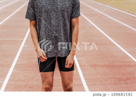 陸上競技のトラックに立つ男性ランナー 100681592