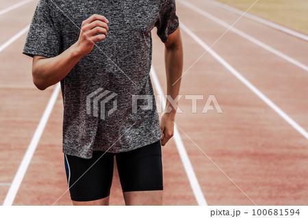 陸上競技のトラックで走る男性ランナー 陸上競技のトラックで走る男性ランナー 100681594