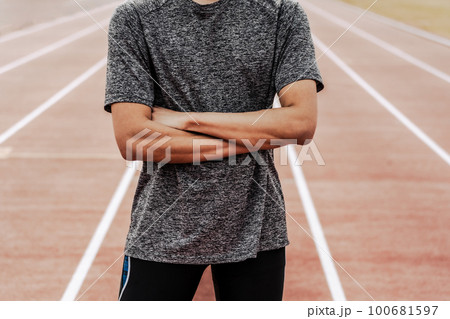 陸上競技のトラックで腕を組む男性ランナー 100681597