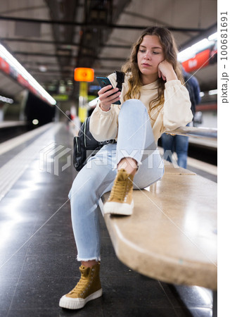 Young attractive girl in jeans waiting for subway train on a platform Young attractive girl in jeans waiting for subway train on a platform 100681691