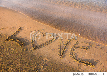Love word written in sand 100683001