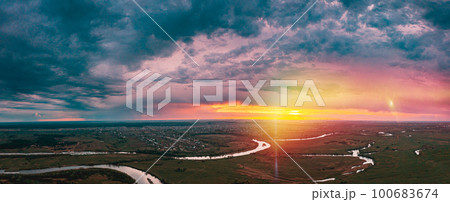 Sunset above river. Panorama Aerial View Green forest And River Landscape In Misty Foggy Morning. Top View Of Beautiful Nature From High Attitude In Summer Season. Bird's Eye View Sunset above river. Panorama Aerial View Green forest And River Landscape In Misty Foggy Morning. Top View Of Beautiful Nature From High Attitude In Summer Season. Bird's Eye View 100683674